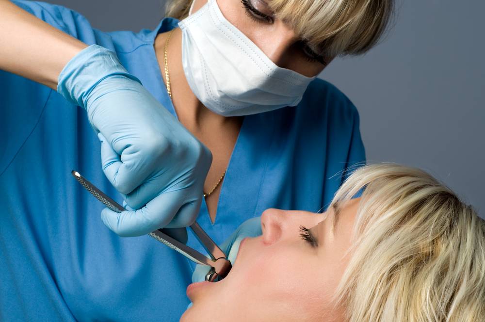 A woman is being examined by a dentist.
	